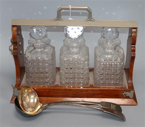 An Army and Navy three bottle tantalus and two serving spoons width 42cm